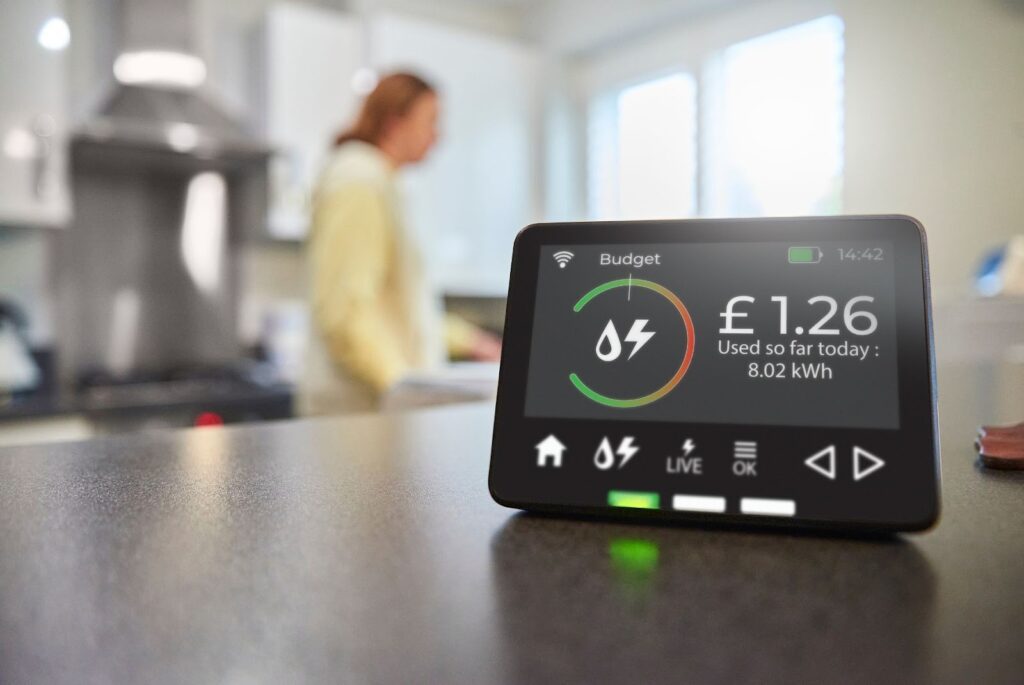 a smart meter showing a daily spend of £1.26, in the foreground of a kitchen